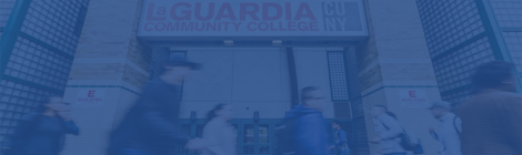 Students walking by the entrance of the E building under the LaGuardia Community College logo.